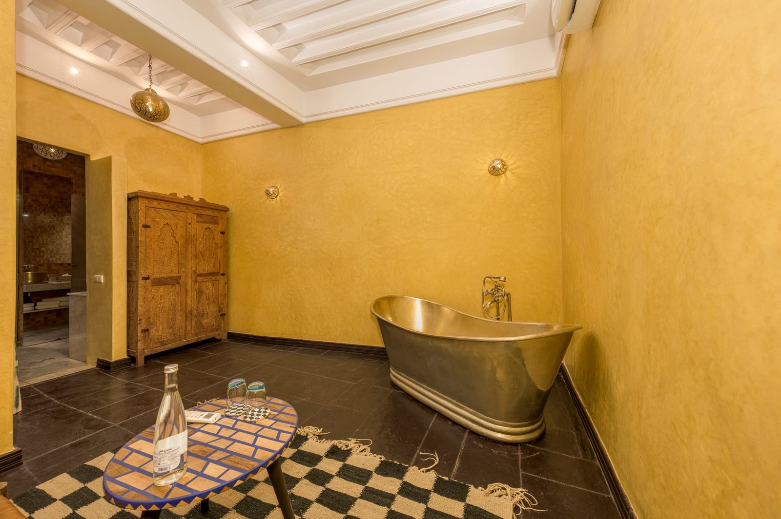 Une baignoire de cuivre martelé dans une salle de bain safran